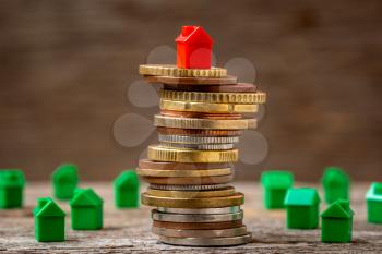Property investment and house mortgage financial concept. Miniature house on stack coins using as property real estate and financial concept.