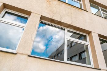 Windows of multistorey building with a blue sky in the reflection