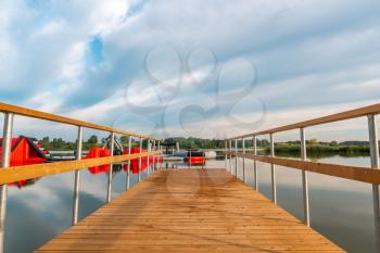 Empty wooden pier and water bouncy park in the lake