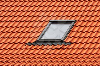 Modern Roof Skylight Window on Red House Clay Ceramic Tiles Roof. Roofing Construction. 