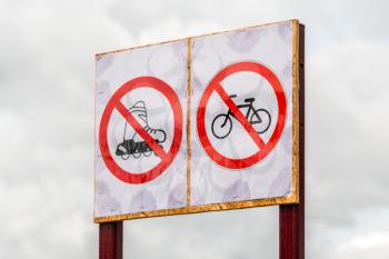 No cycling or skating permitted sign against the rainy sky background