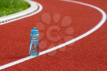 Water bottle on a race track, warm summer day.Thirst and water balance concept.