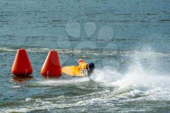 Powerboat go fast along the lake and rounding a marker buoy in a race