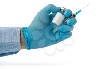 
Doctor, nurse or scientist hand in blue nitrile glove holding flu, measles, coronavirus (COVID-19) vaccine and syringe injection. Medicine and drug concept. Copy space.