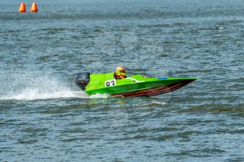 Powerboat with number 83 go fast along the lake at powerboat racing