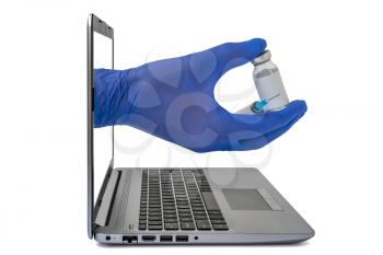 Technology And Medicine concept. Laptop computer and hand with a bottle of medicine or vaccine and medical syringe  for injection.