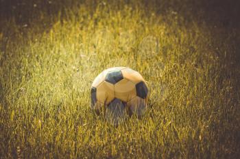 Yellow soccer ball in stadium on a sunny morning