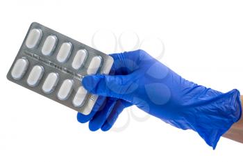 Doctor or scientist hand in blue nitrile glove holds a blister with pills.  Healthcare concept.