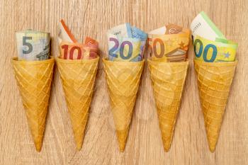 Euro bills rolled in ice cream cones. Waffle cones and money.