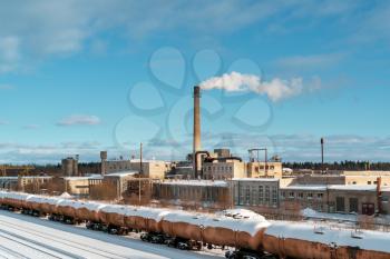 Aerial view of freight train. Railway station with wagons. Heavy industry. Industrial landscape with train in depot, chimney with smoke stack, factory buildings. 