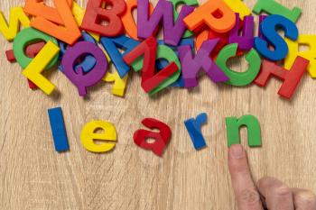 Hand arrange color plastic letters as LEARN word