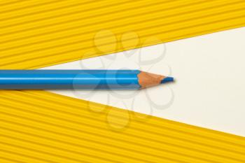 Template with copy space by top view closeup photo of blue pencil put between yellow paper 