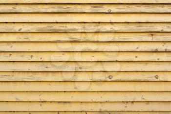 Close up of wall made of  yellow painted wooden planks