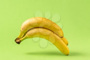 Bunch of yellow banana levitating on a green background
