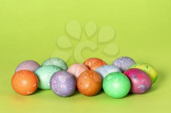 Colorful handmade easter eggs on a green background