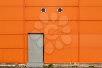 Industrial orange building wall with metal doors