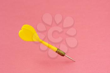 Yellow dart arrow on the pink background. Copy space.
