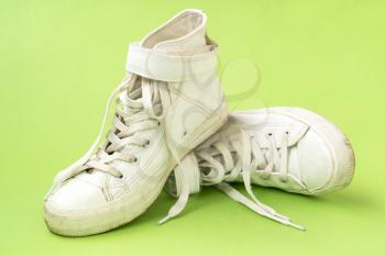 Pair of white leather shoes on the green background
