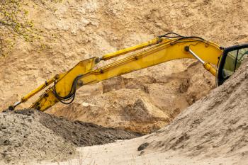 Excavator machine working at sand quarry. Construction industry.