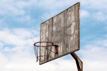 Old wooden ghetto style basketball hoop. Basketball ring with chains against  sky background