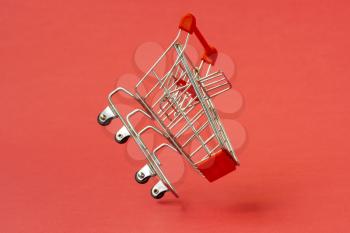 Metal mini shopping trolley on a red background. Sales concept.