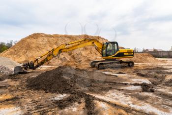Excavator working at sand quarry. Construction industry.