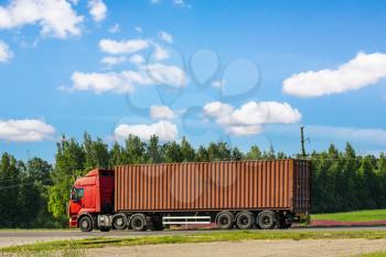 Truck on the road with red container. Cargo shipping and transportation concept.