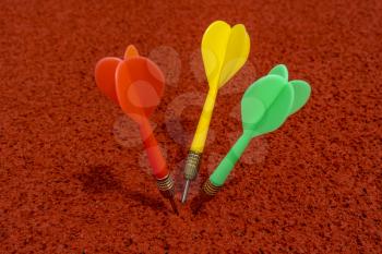 Red, green and yellow colored dart arrows on a running track in a stadium