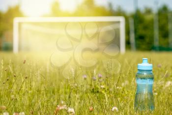 Sport bottle of water on football field grass