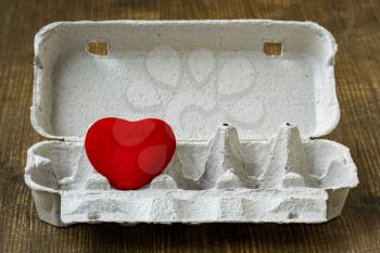 Concept: creative Valentine's day. Red heart in a cardboard egg box. 