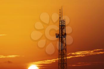 Silhouette of telecommunication tower with cellular network antennas during sunset