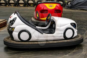 White and red bumper cars at the amusement park. Fairground with attractions. Colorful dodgems.