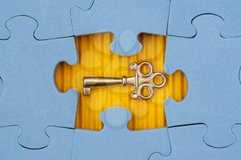 Find key to success, business opportunity or solution. Blue jigsaw puzzle with small key.