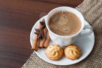 Hot cup of  coffee  on sack with cookies