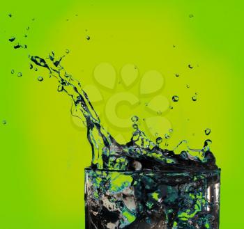 Water splash in glass on light green background