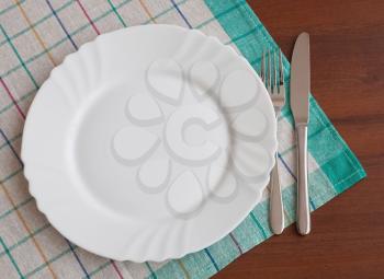 Dining time. Plate with silverware on table