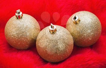 Golden christmas balls on red fur