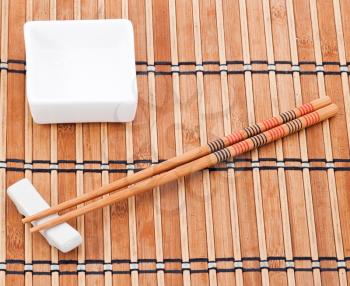 Chopsticks and bowl on bamboo background