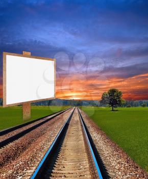 Railway on beautiful summer evening with placard in field