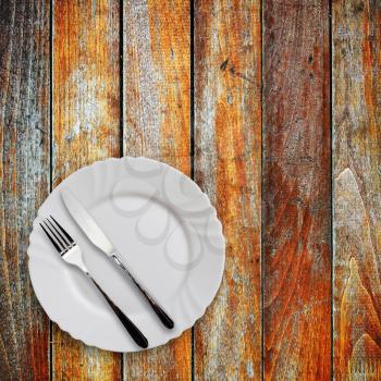 Plate fork and knife on old wood table