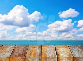 Wooden pier on sunny day with cloudy sky