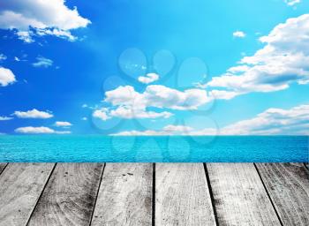 Wooden gray pier on sunny day with blue sky