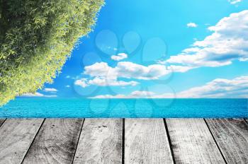 Wooden gray pier on sunny day with blue sky