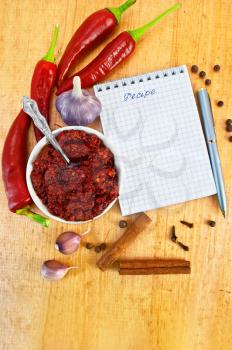 Royalty Free Clipart Image of a Cup of Chopped Chilies With Peppers and a Notepad