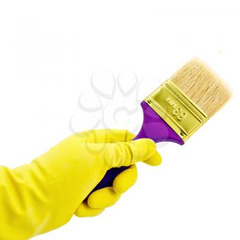 Paint brush in hand with a yellow rubber glove isolated on white background