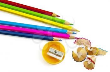 Blue, pink, yellow, green, maroon pencils, pencil sharpener and a yellow color chips isolated on a white background