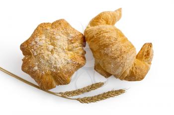Croissant and bread roll with stalks of wheat in isolation on a white background