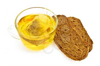 Green herbal tea from a bag in a glass bowl, two pieces of rye bread isolated on white background