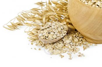 Oat flakes in a wooden bowl and spoon, stalks of oats isolated on white background