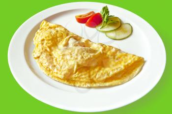 Yellow omelet, two slices of red tomatoes and cucumber, a sprig of parsley on the dish isolated on green background